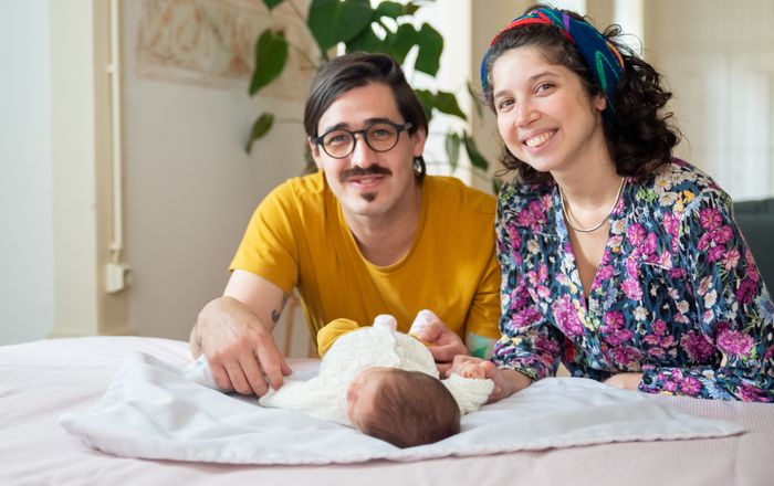 Papás sonrientes con su bebé recién nacido en casa