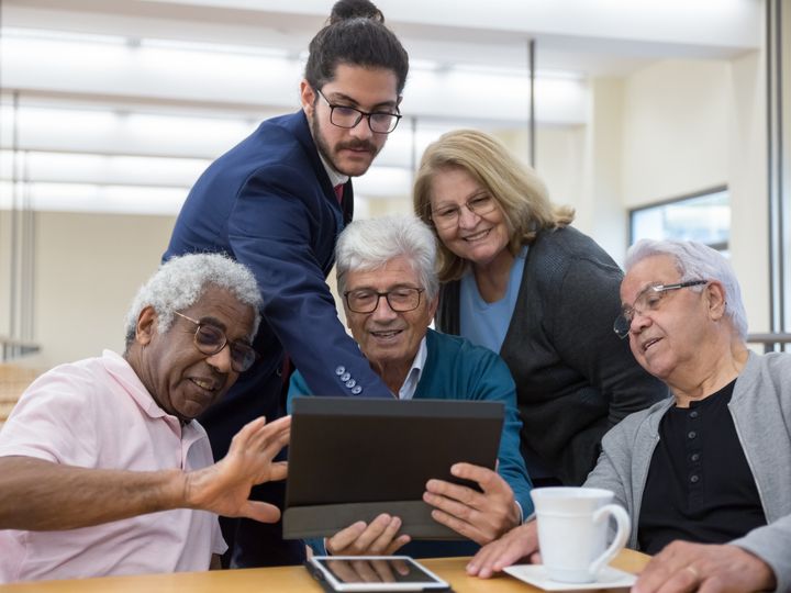 Older adults reviewing information on a tablet with an advisor