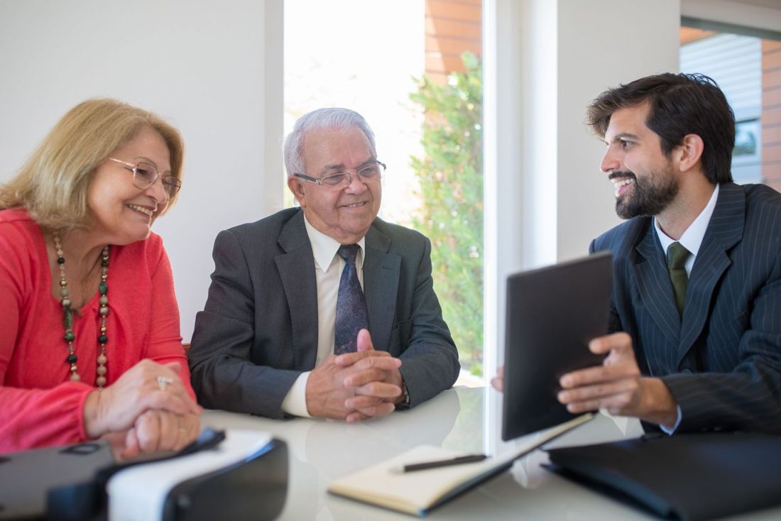 Agent showing options on a tablet to an older couple