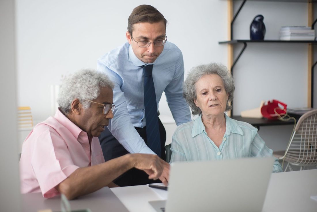Agent helping an older couple at a computer