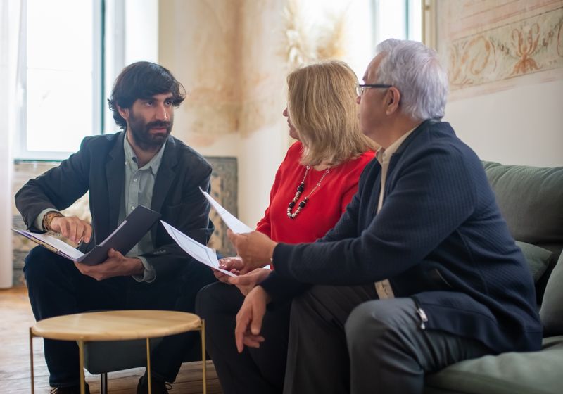 Advisor reviewing plan options with a couple in their living room