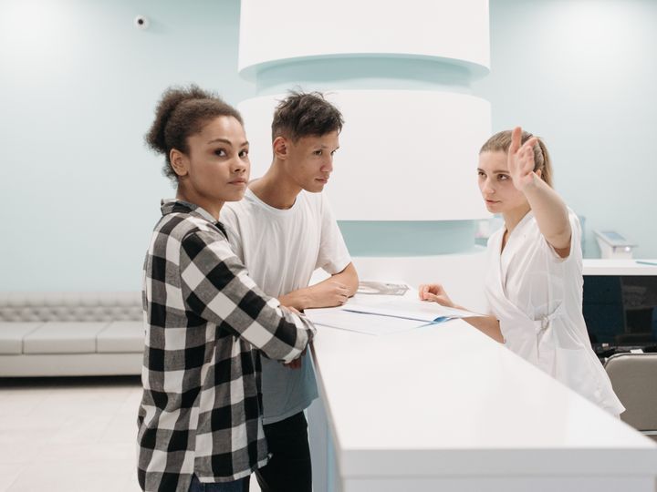 People at a medical clinic reception desk